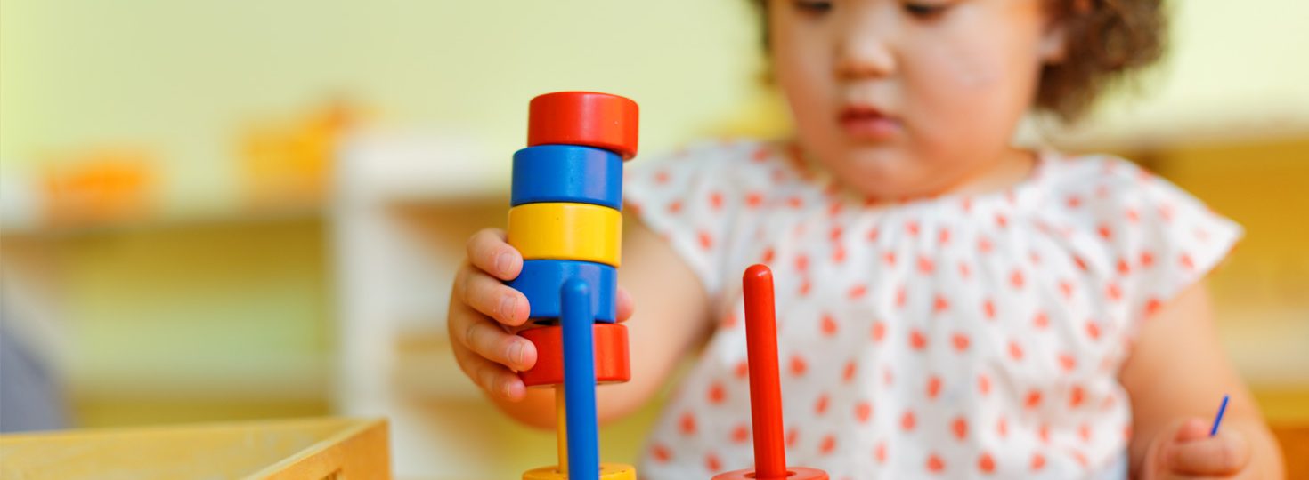 Child playing with stacking toy