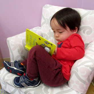child reading on a comfy chair