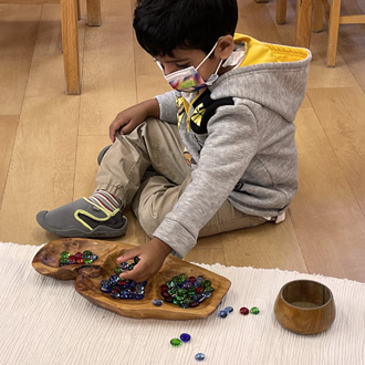 Child playing with colored glass stones